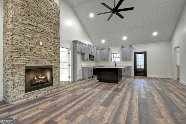 kitchen featuring light countertops, dark wood-style flooring, stainless steel microwave, and gray cabinetry