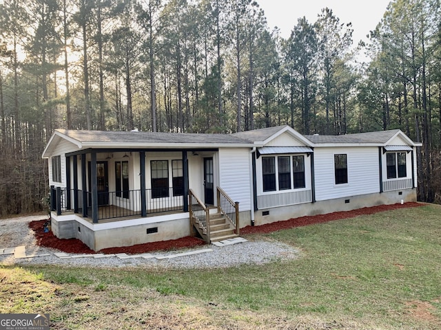 manufactured / mobile home featuring crawl space, covered porch, and a front lawn