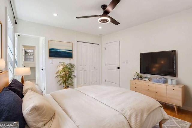 bedroom featuring a closet, wood finished floors, a ceiling fan, and recessed lighting