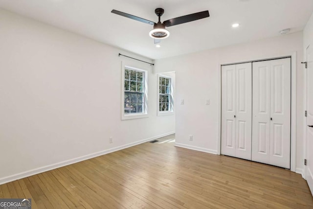 unfurnished bedroom featuring light wood finished floors, visible vents, baseboards, and a closet