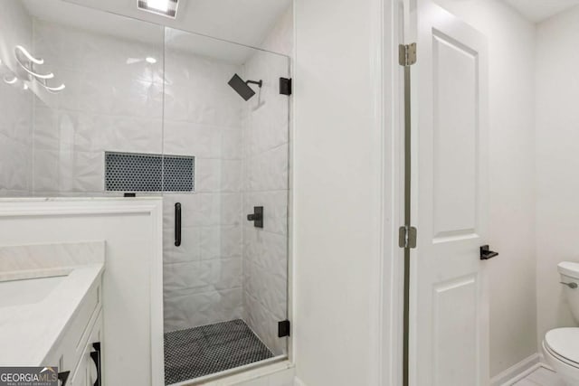 bathroom featuring toilet, visible vents, vanity, baseboards, and a stall shower