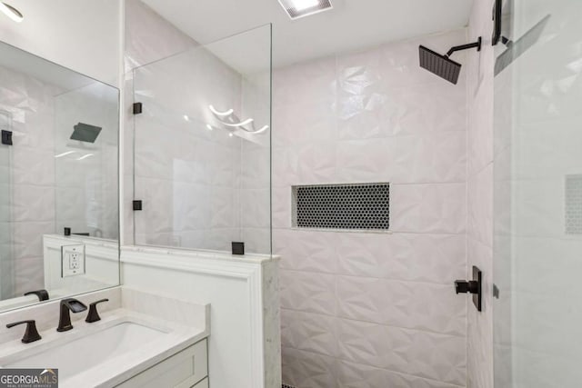 bathroom with vanity, walk in shower, and visible vents