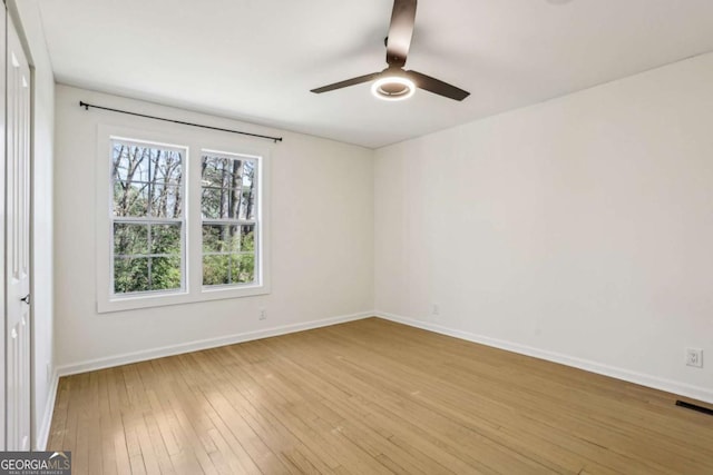 interior space with ceiling fan, light wood-type flooring, visible vents, and baseboards