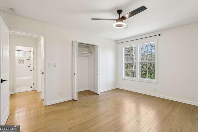 unfurnished bedroom with attic access, light wood-type flooring, a closet, and baseboards