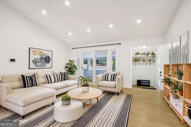 living room featuring lofted ceiling, light wood finished floors, and recessed lighting