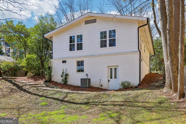 view of property exterior with central air condition unit and brick siding