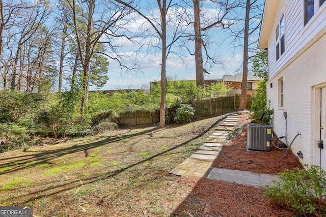 view of yard featuring fence and central air condition unit