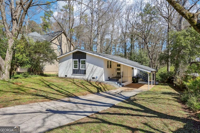 mid-century modern home with driveway, brick siding, a carport, and a front yard