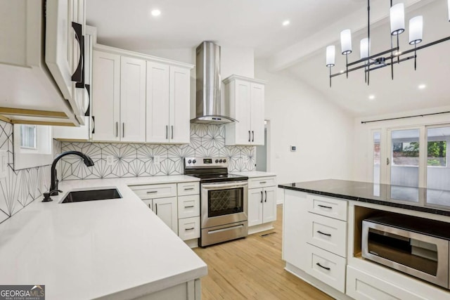 kitchen featuring stainless steel appliances, lofted ceiling with beams, backsplash, a sink, and wall chimney exhaust hood