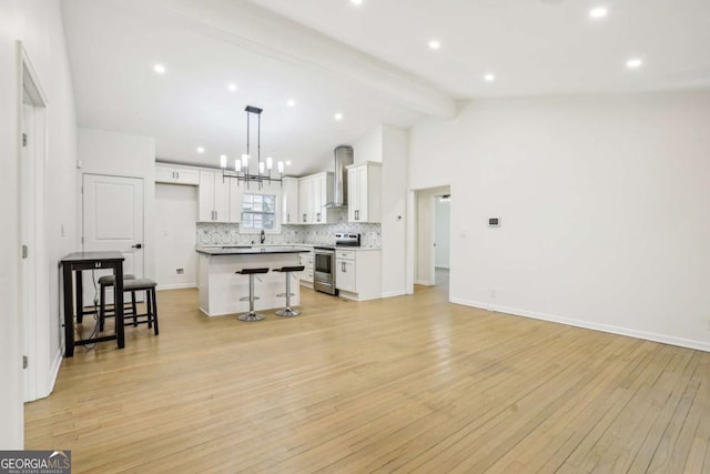 kitchen with vaulted ceiling with beams, a breakfast bar area, electric range, light wood-type flooring, and decorative backsplash