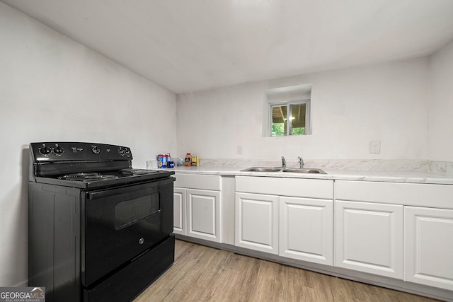 kitchen featuring light wood finished floors, black / electric stove, a sink, and white cabinetry