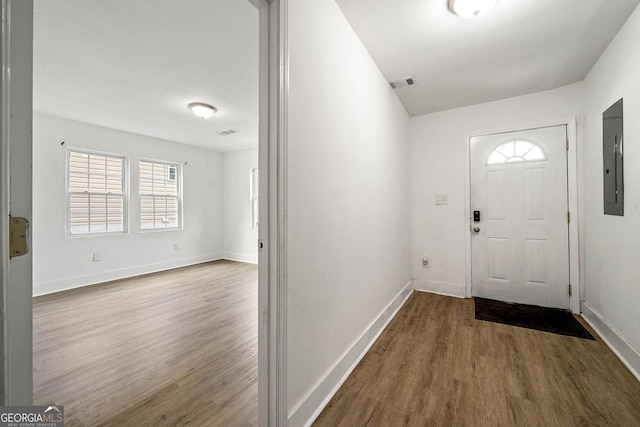 foyer featuring visible vents, wood finished floors, electric panel, and baseboards