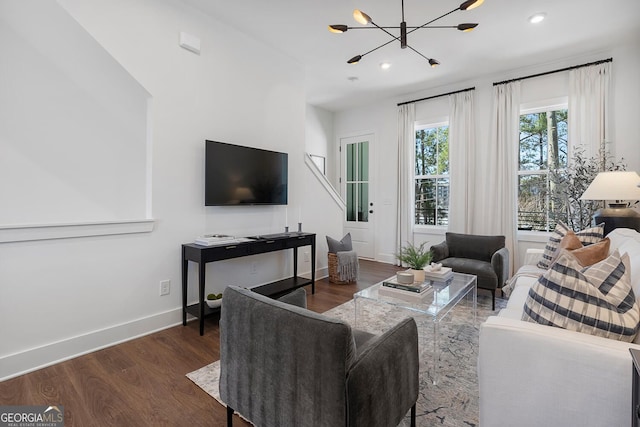 living room featuring a chandelier, recessed lighting, baseboards, and wood finished floors