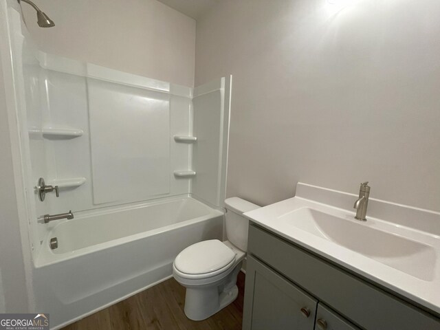 full bathroom featuring toilet,  shower combination, wood finished floors, and vanity