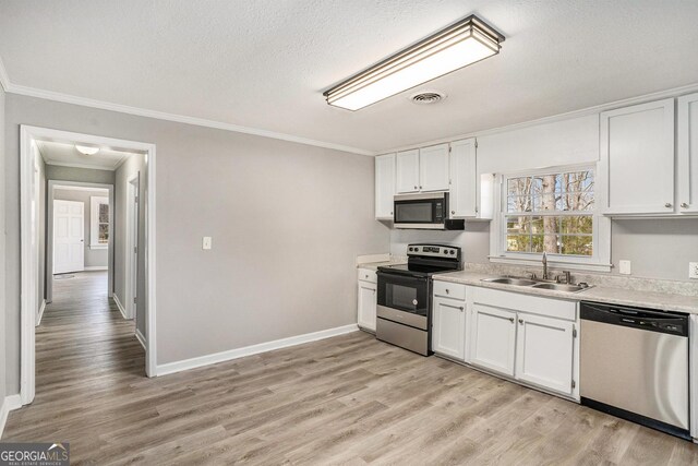 1887 Green Valley Rd, Griffin, GA 30224 - kitchen with light countertops, appliances with stainless steel finishes, light wood-style floors, white cabinets, and a sink