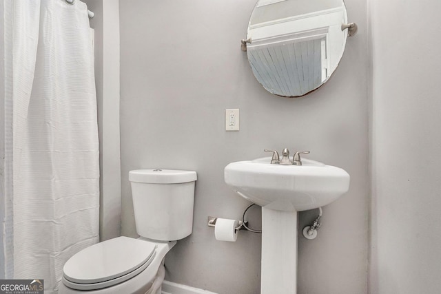 1887 Green Valley Rd, Griffin, GA 30224 - bathroom featuring curtained shower, toilet, and baseboards