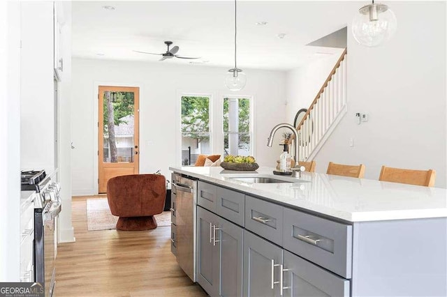 kitchen featuring appliances with stainless steel finishes, gray cabinets, a sink, and a wealth of natural light