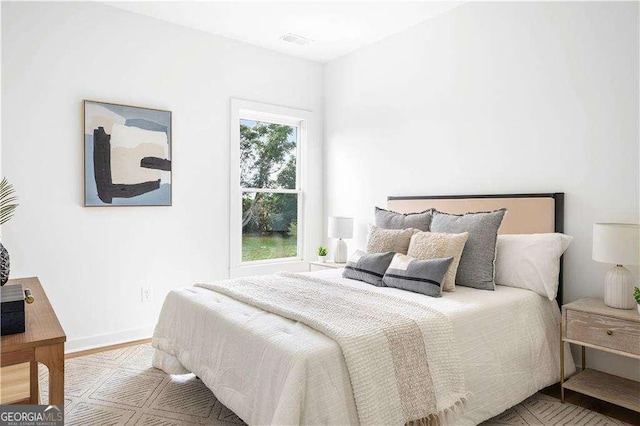 bedroom featuring wood finished floors, visible vents, and baseboards