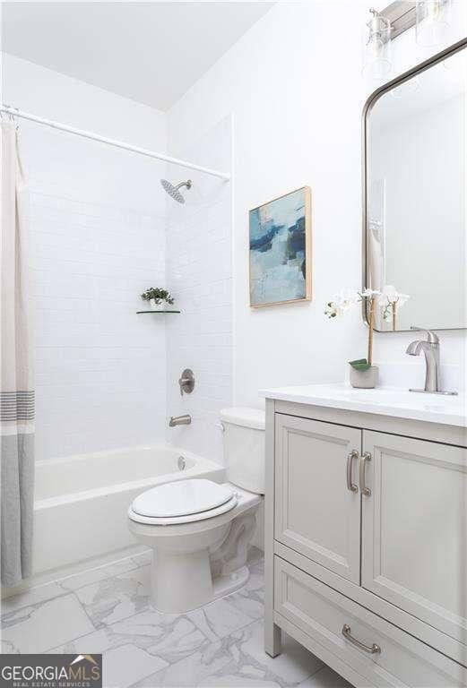 full bathroom with shower / bath combo, marble finish floor, vanity, and toilet