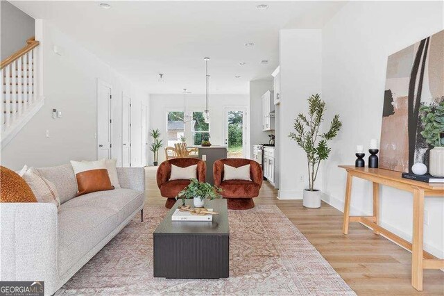 living room with light wood-type flooring and stairway