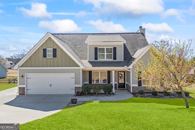 craftsman inspired home featuring stone siding, a front yard, covered porch, and driveway