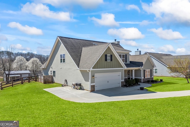 exterior space with a shingled roof, concrete driveway, fence, a yard, and board and batten siding