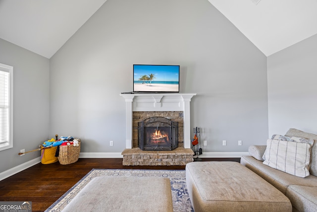 living room with high vaulted ceiling, baseboards, wood finished floors, and a stone fireplace