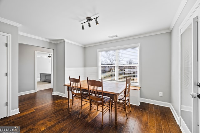 dining space with ornamental molding, wood-type flooring, visible vents, and baseboards