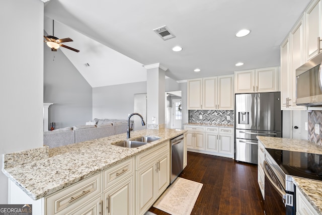 kitchen with dark wood-style flooring, a sink, visible vents, appliances with stainless steel finishes, and decorative backsplash