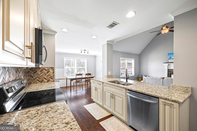 kitchen with visible vents, open floor plan, stainless steel appliances, cream cabinetry, and a sink