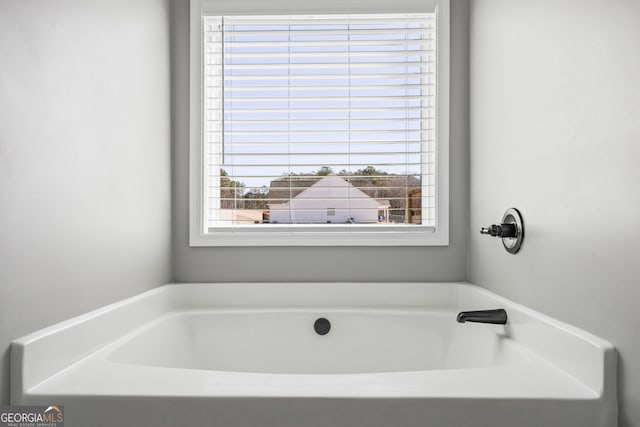 full bath with a healthy amount of sunlight and a garden tub