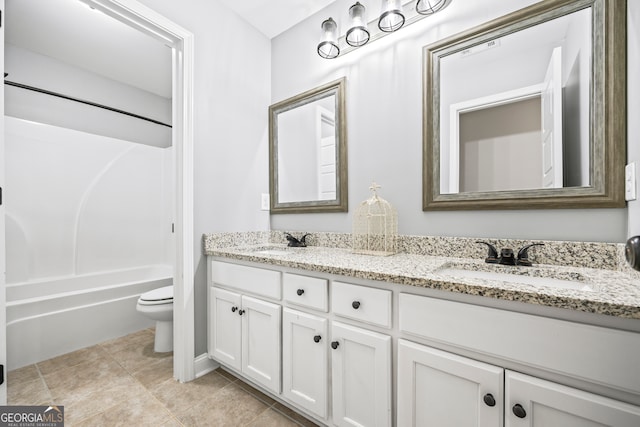 bathroom with tile patterned floors, a sink, toilet, and double vanity