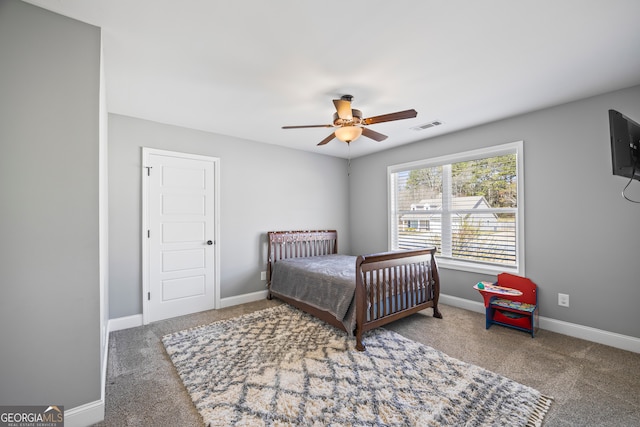 carpeted bedroom featuring a ceiling fan, visible vents, and baseboards