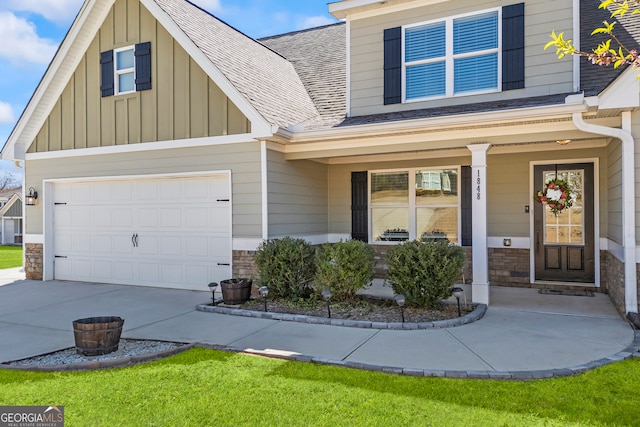 view of front facade featuring a porch, a garage, a shingled roof, stone siding, and board and batten siding