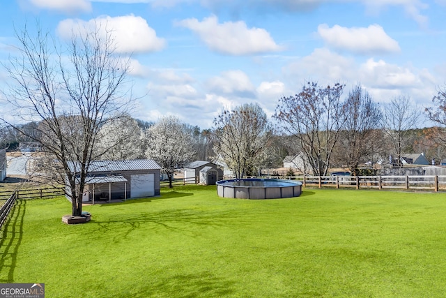 view of yard with fence, a fenced in pool, and an outbuilding