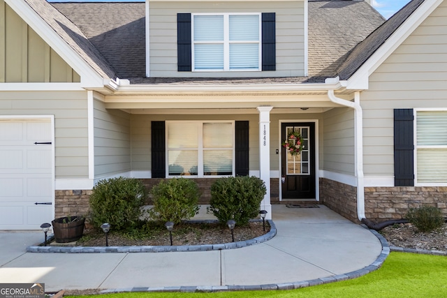 view of exterior entry with stone siding, a shingled roof, a porch, and board and batten siding