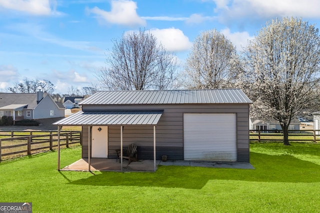 detached garage featuring fence and a residential view