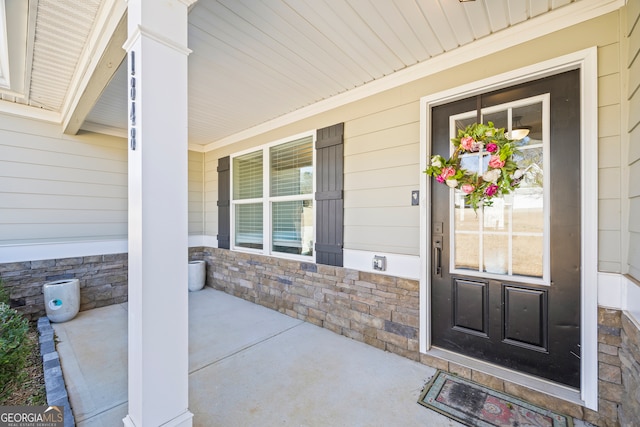 entrance to property with covered porch and stone siding