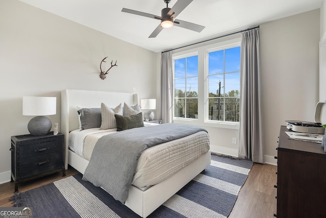 bedroom featuring a ceiling fan, dark wood finished floors, and baseboards