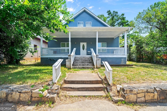 bungalow-style home featuring covered porch and a front lawn