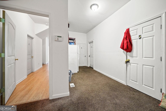 hallway featuring baseboards and carpet flooring