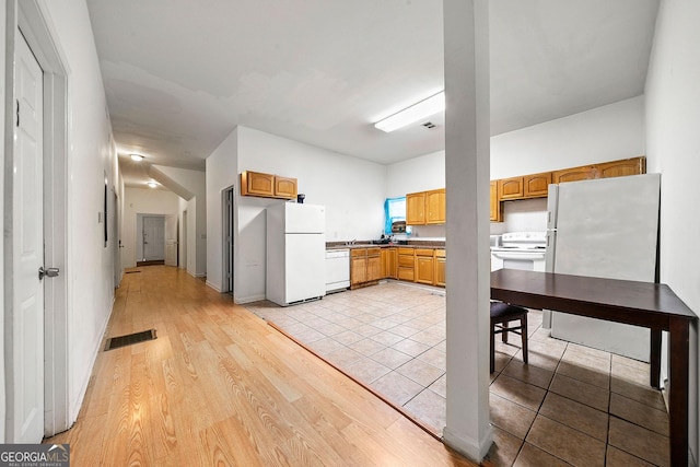 kitchen featuring light wood-type flooring, white appliances, baseboards, and visible vents