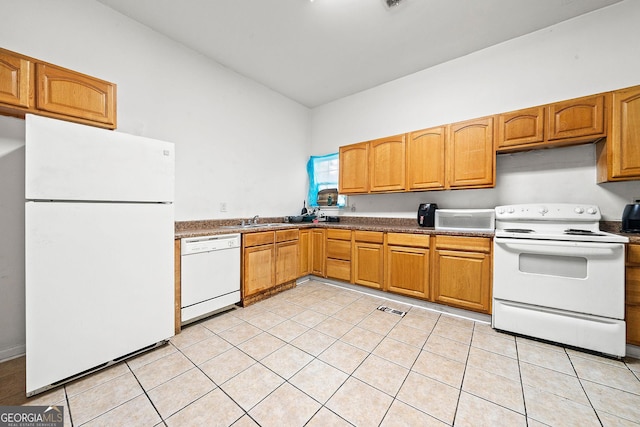 kitchen with light tile patterned floors, white appliances, a sink, visible vents, and dark countertops