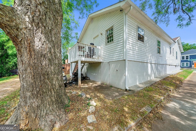 view of side of property with stairs and a wooden deck