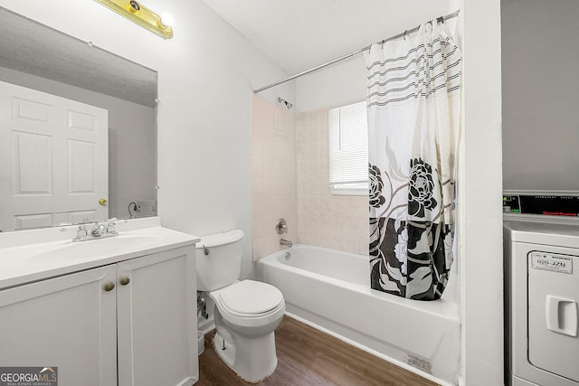 bathroom featuring shower / tub combo, washer / dryer, toilet, wood finished floors, and vanity