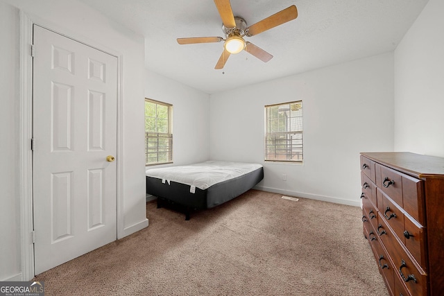 bedroom featuring ceiling fan, carpet, visible vents, and baseboards