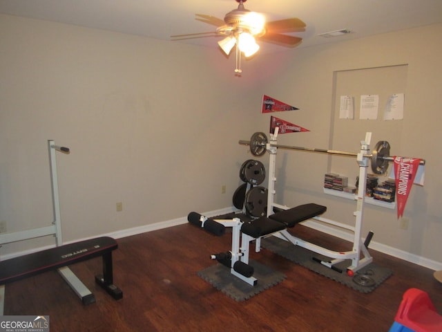 exercise area featuring a ceiling fan, baseboards, visible vents, and wood finished floors