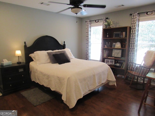 bedroom featuring dark wood-style floors, visible vents, and a ceiling fan