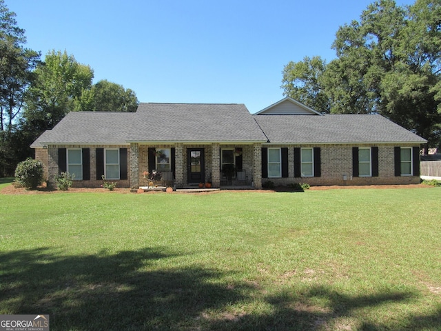 ranch-style house featuring a front yard, brick siding, and roof with shingles