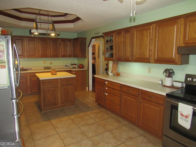 kitchen with arched walkways, a textured ceiling, under cabinet range hood, appliances with stainless steel finishes, and a raised ceiling